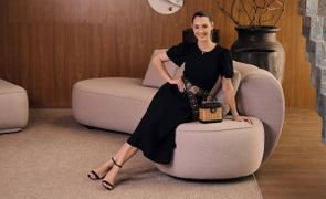 mulher pousando para foto sentada em um sofa